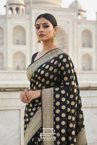 Woman in a black and gold Banarasi Georgette saree in front of the Taj Mahal.
