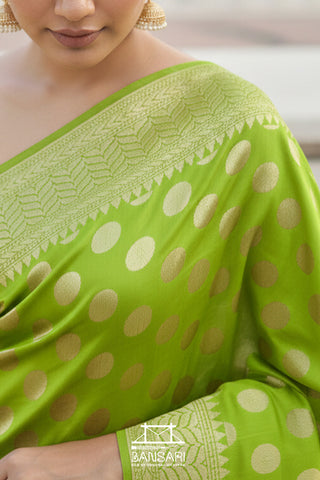 Green saree with white polka dots worn by a person, brand 'Banarsi' visible.