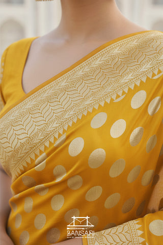 Yellow saree with white polka dots and intricate border, brand 'Banarsi' visible.