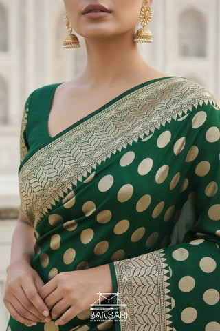 Green saree with gold polka dots and intricate border, worn by a model.